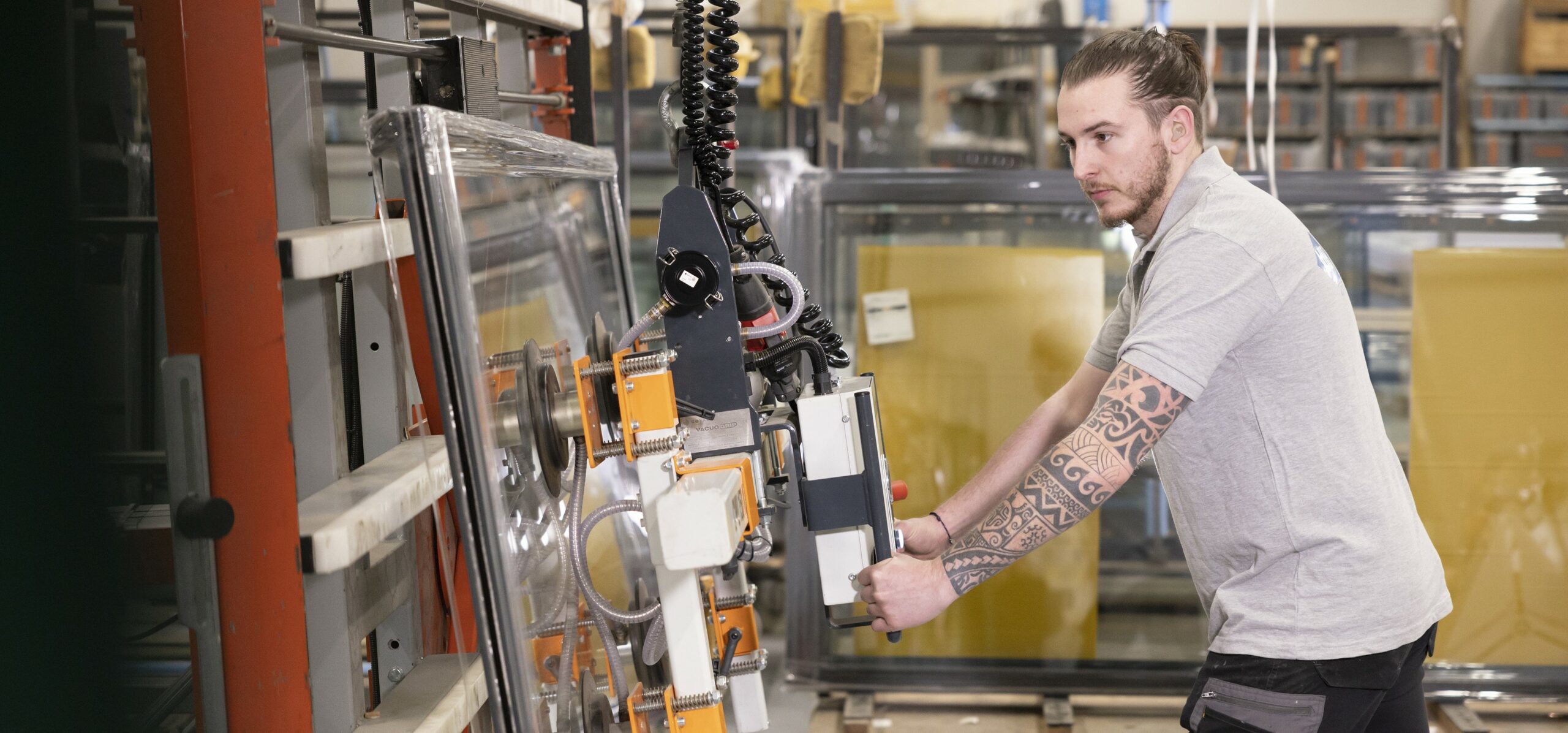 Technicien manipulant une barre aluminium dans l'atelier