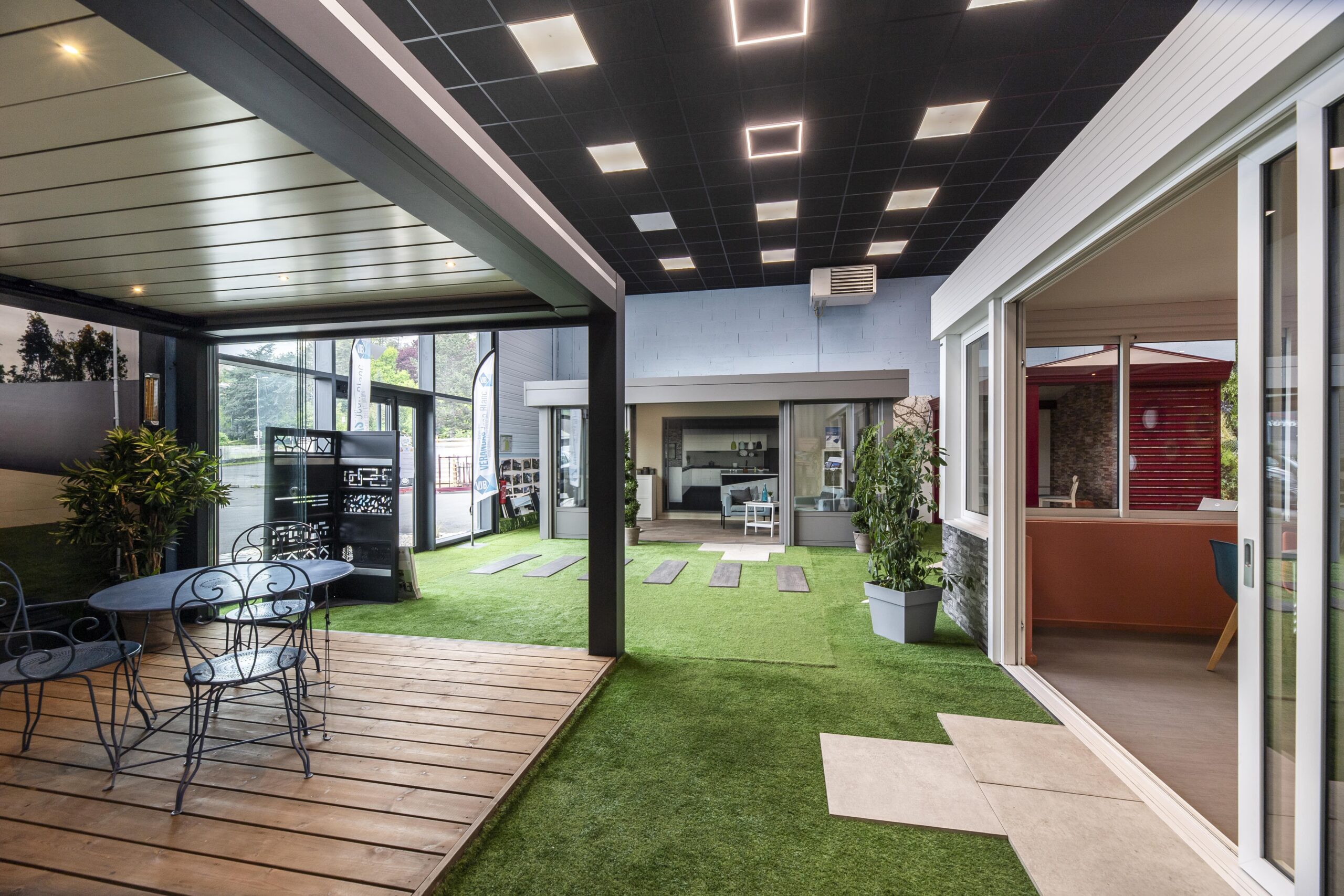 Intérieur du showroom de L'Étrat avec exposition de véranda jardin d'hiver