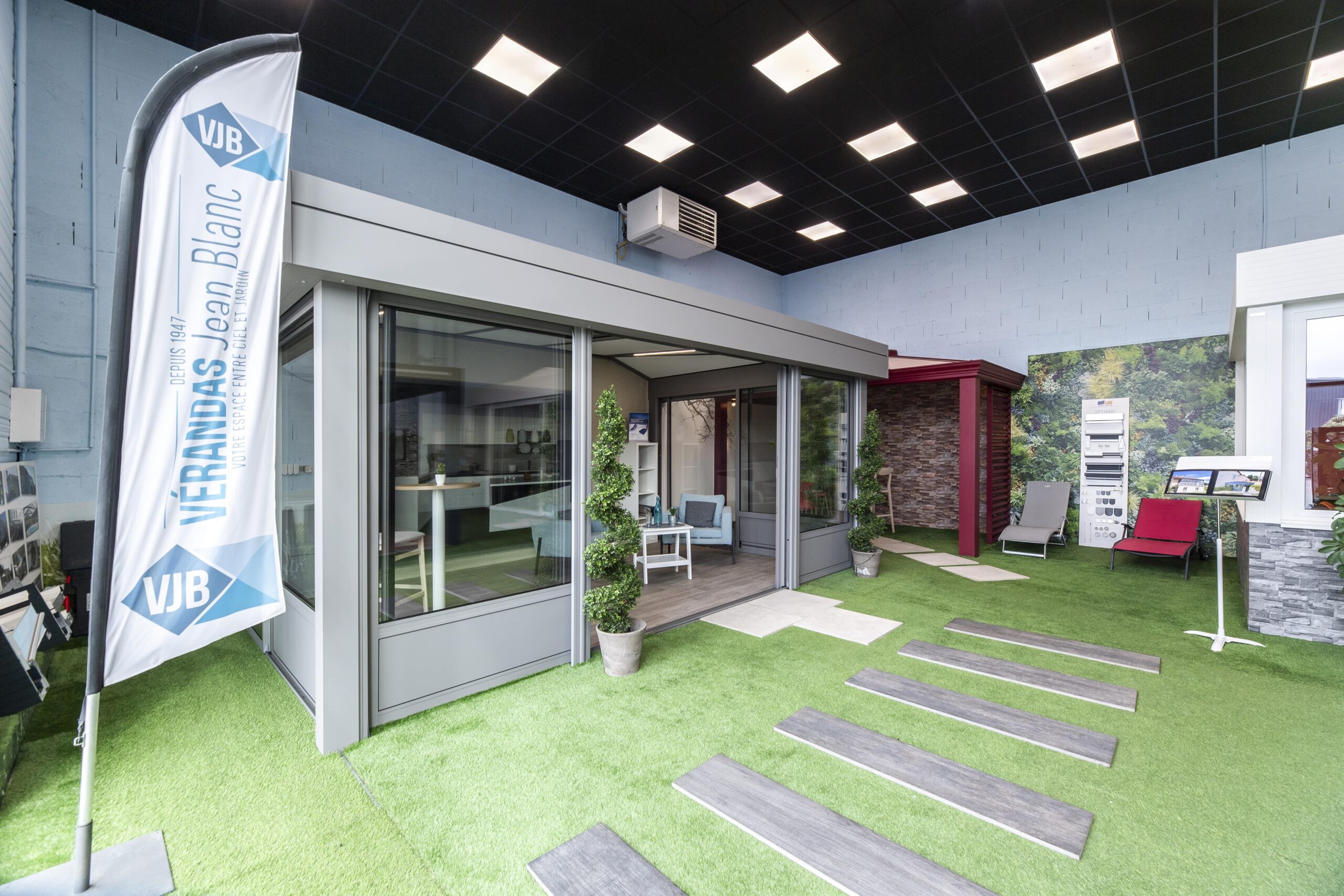 Intérieur du showroom de L'Étrat avec exposition de véranda jardin d'hiver