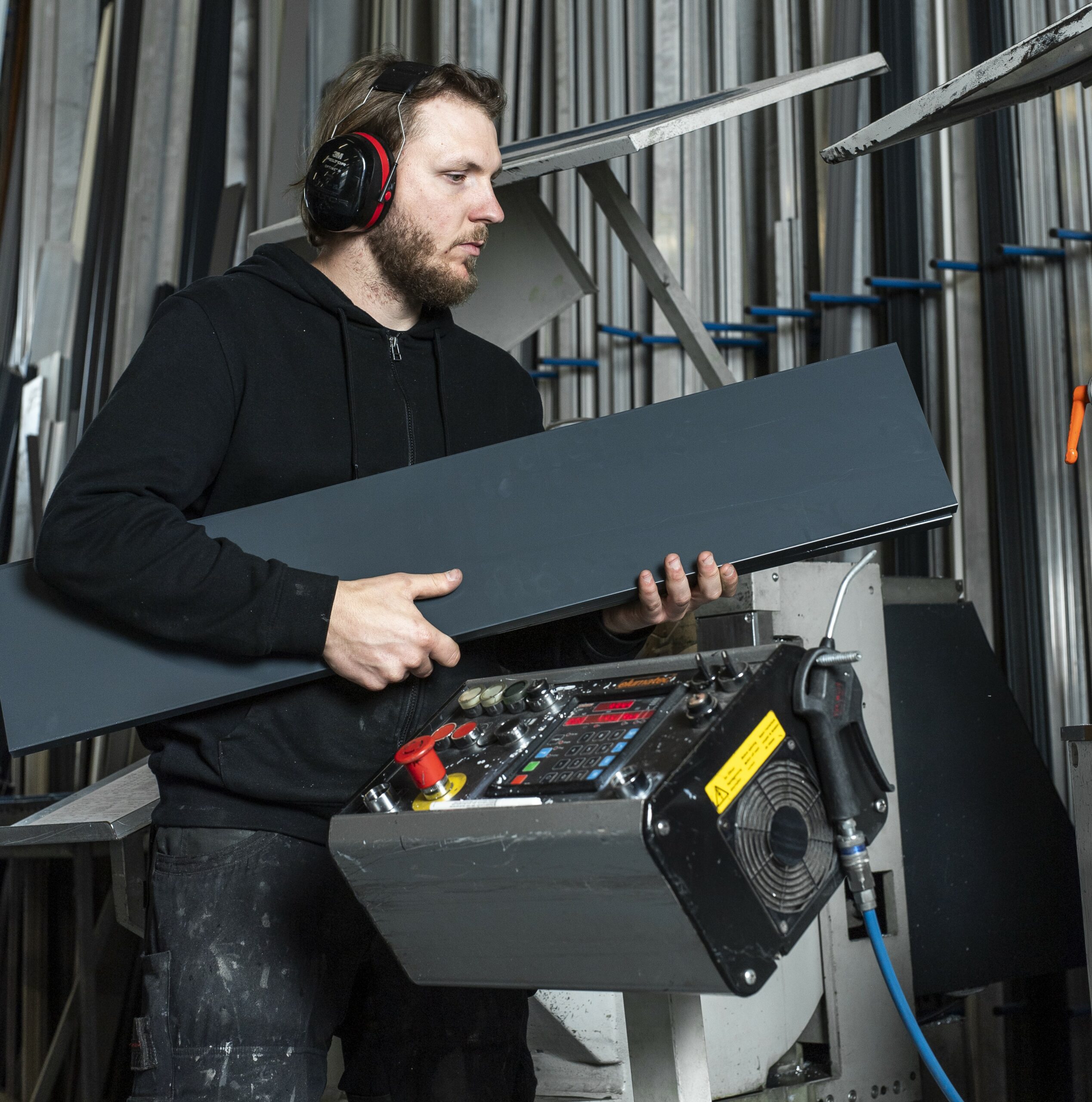 Technicien manipulant une barre aluminium dans l'atelier