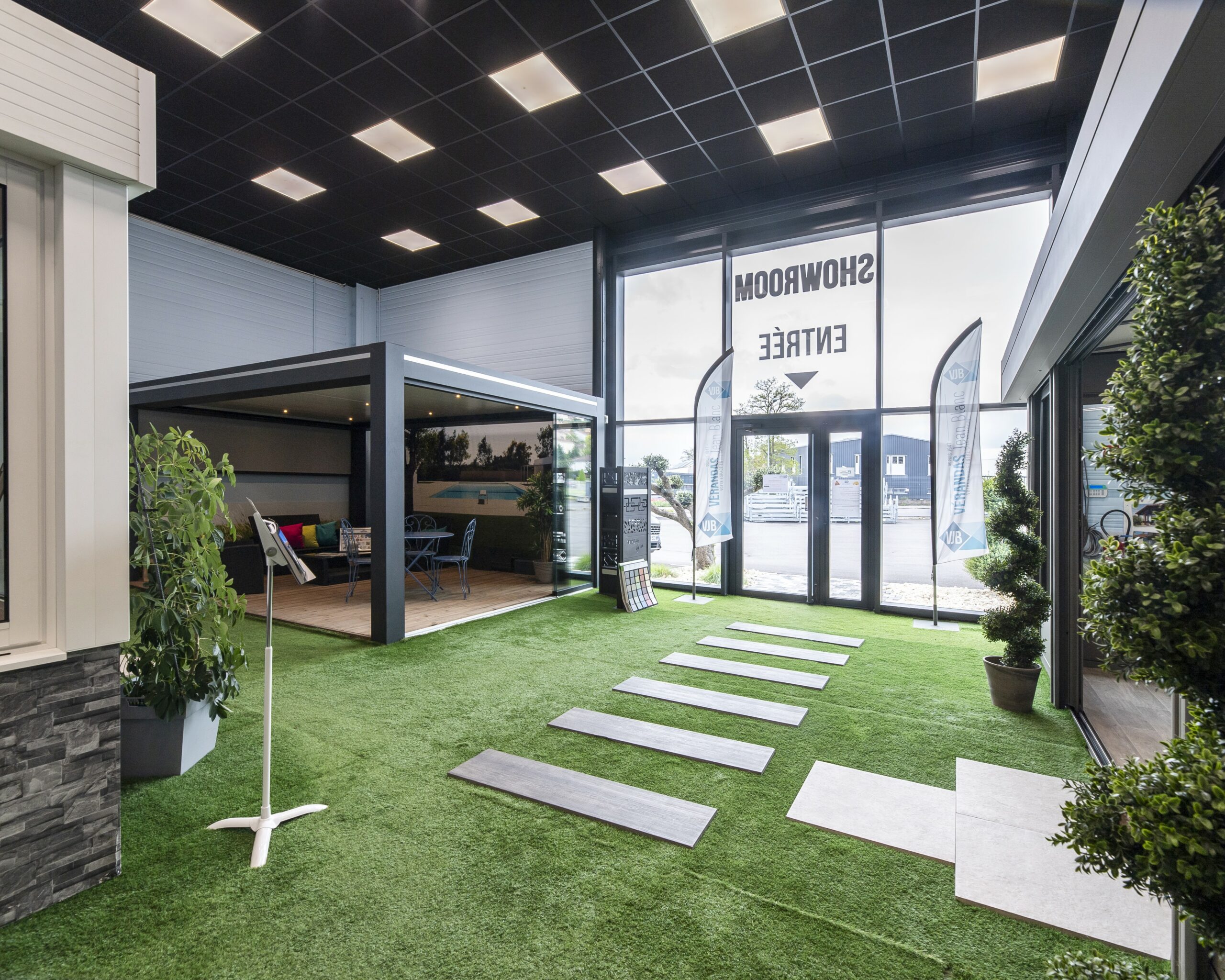 Intérieur du showroom de L'Étrat avec exposition de véranda jardin d'hiver